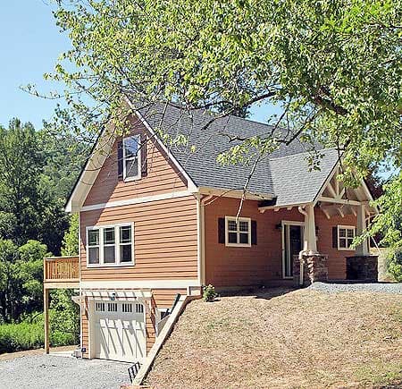 House plan exterior: Two-story home with attached garage, front porch with stone columns, and gabled dormer.
