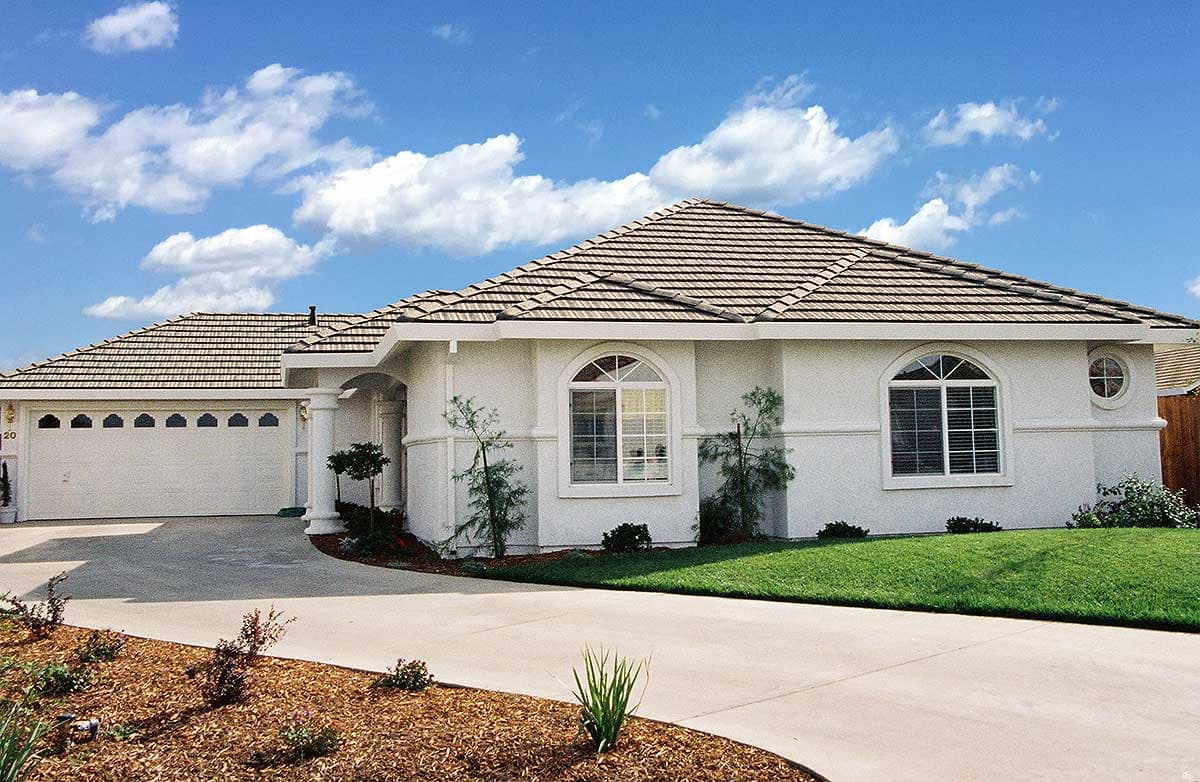 House plan exterior: One-story Ranch with tiled roof, arched windows, and attached two-car garage.