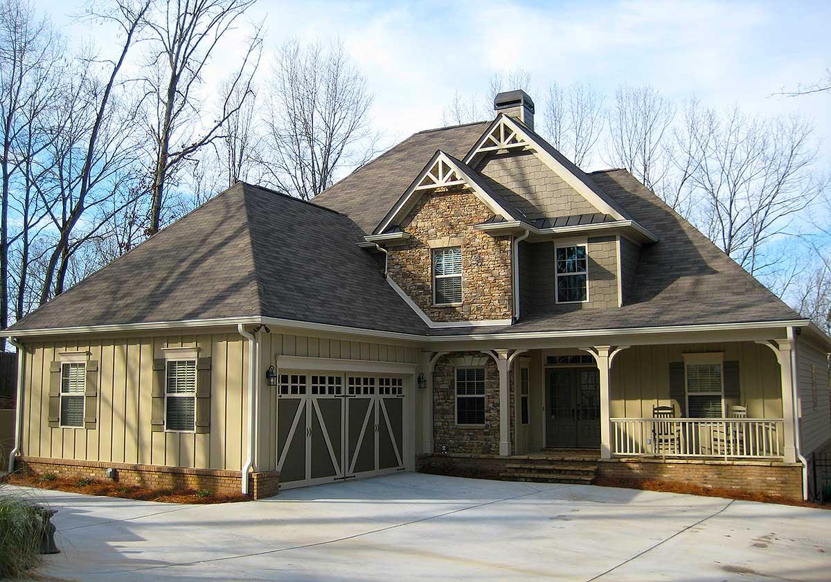 House plan exterior with stone accents, covered porch, and gabled roof. Two-story Craftsman style home with attached garage.