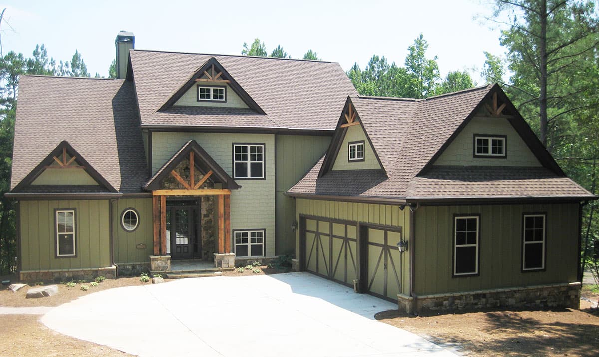 House plan exterior: Two-story Modern Farmhouse with prominent gables, exposed timber accents, stone base, and a three-car garage.