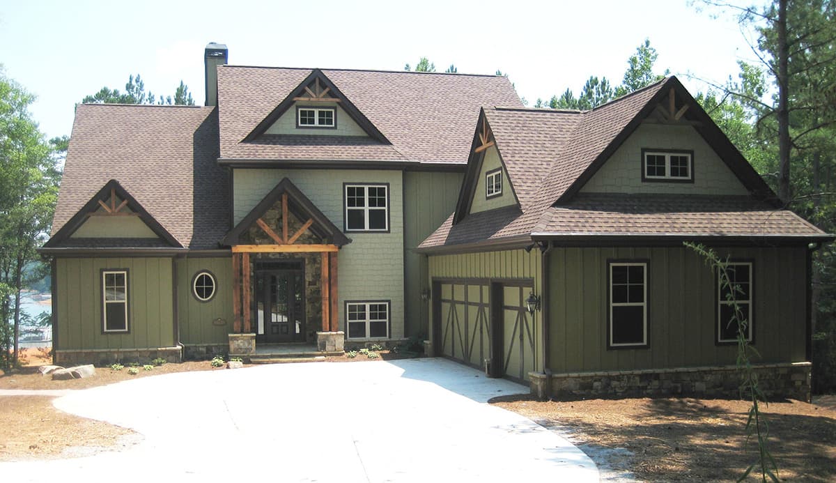 Modern Farmhouse style house plan exterior, two stories, with prominent gables, stone foundation, and attached two-car garage.