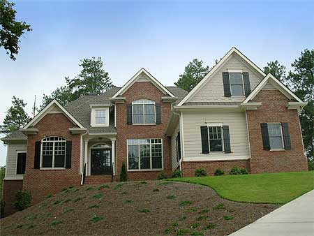 House plan exterior of a two-story brick home with multiple gables, arched windows, and a central covered entrance.