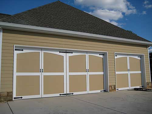House plan exterior with three tan garage doors featuring arched top panels and white trim, set against tan horizontal siding.