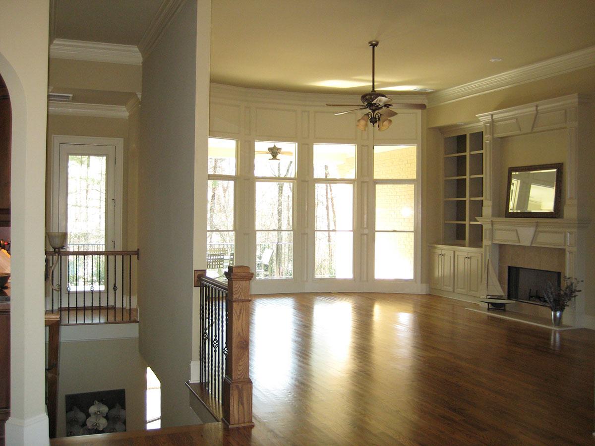 Interior view of a great room with a bay window, built-in shelving, and fireplace.