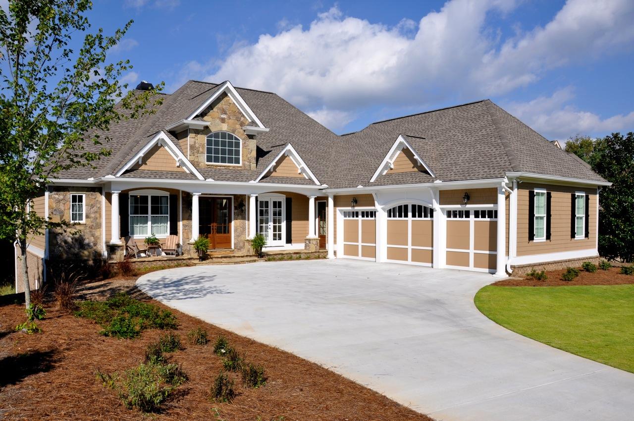 House plan exterior with stone accents, covered entry porch with columns, and a three-car garage.