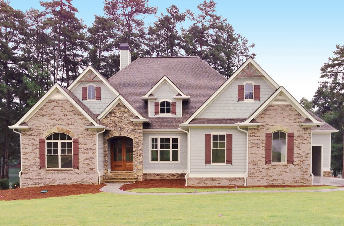 House plan exterior: Two-story Modern Farmhouse with stone-accented arched entry, dormers, gables, and attached garage.