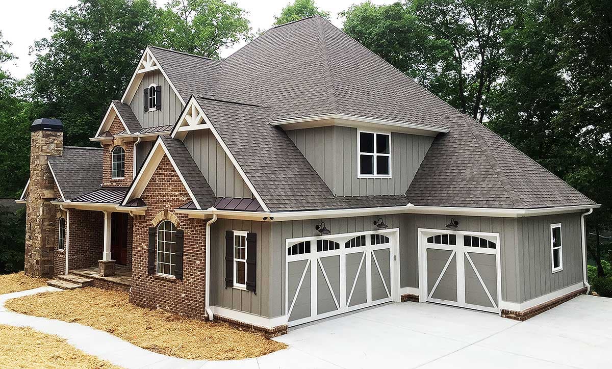 House plan exterior featuring brick accents, a covered porch, gabled dormers, and a three-car garage.