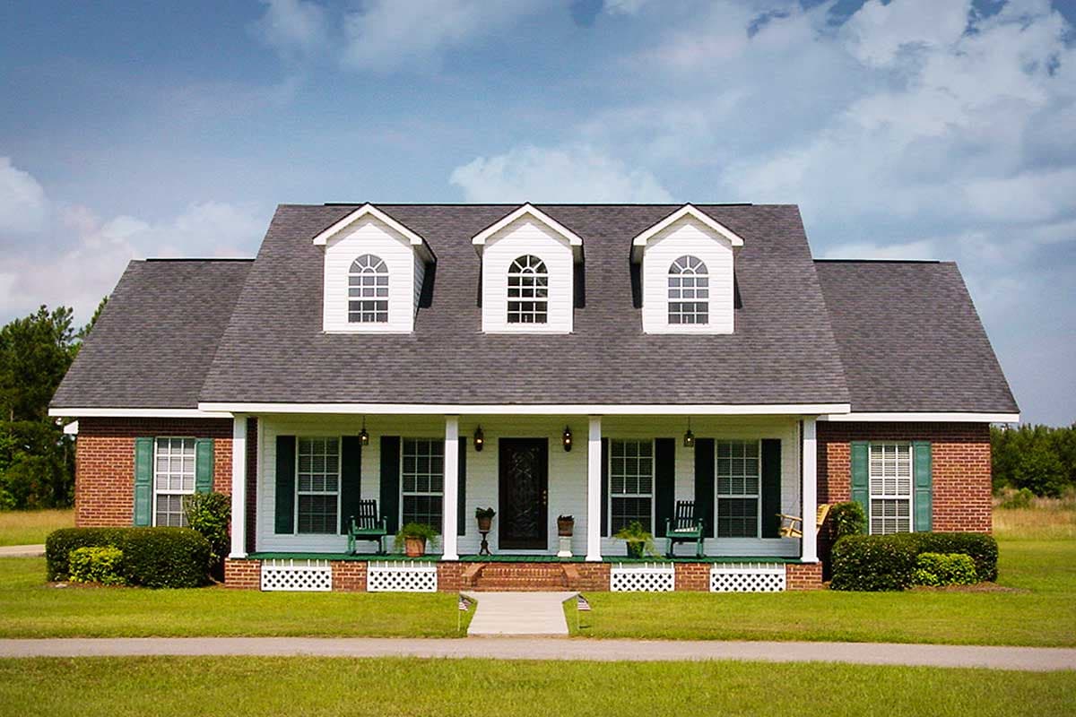 House plan exterior: Brick two-story home with full-width porch, three dormer windows, and a symmetrical facade.