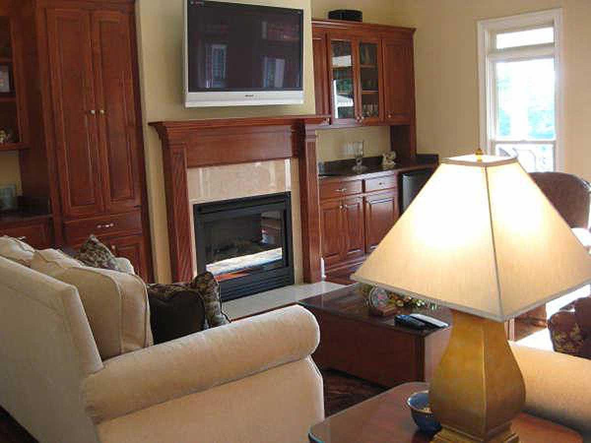Living room with gas fireplace, built-in cabinetry, media console, and sofa.