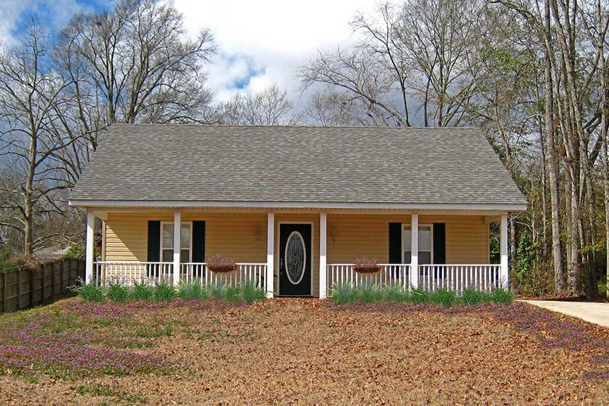 Ranch-style house plan exterior with a covered front porch, white railings, and a central entry door with sidelight windows.