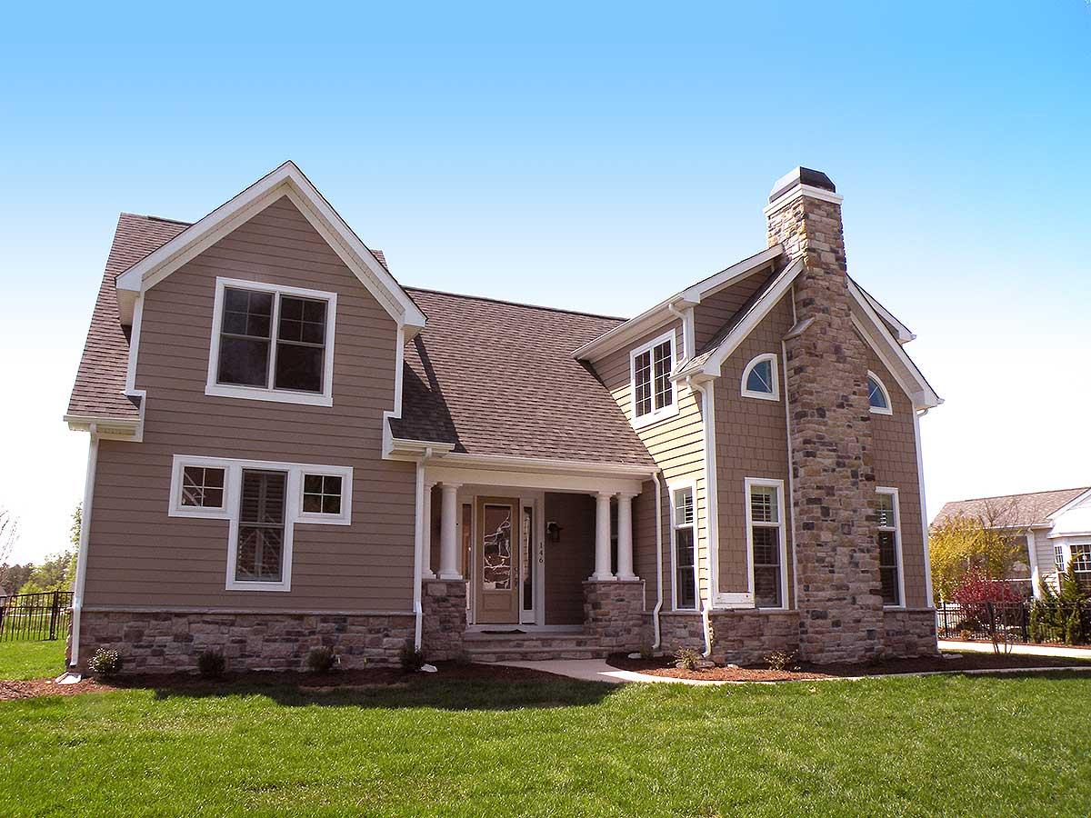 House plan exterior shows a two-story home with stone base, prominent stone chimney, and covered entry with columns.