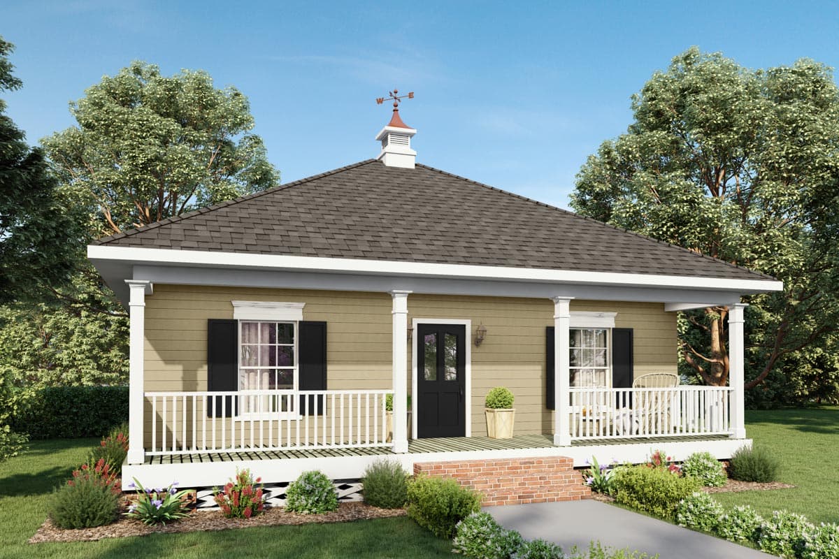A quaint, tan bungalow with a front porch, black shutters, and a decorative weathervane atop the roof, framed by mature trees against a blue sky.