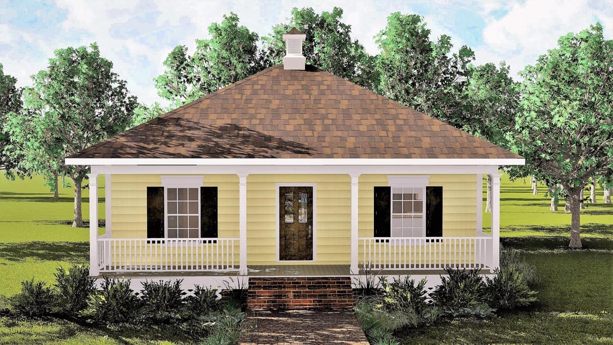 A yellow house with a porch and brown roof stands amongst trees under a cloudy sky. The front door is brown with a decorative glass panel.