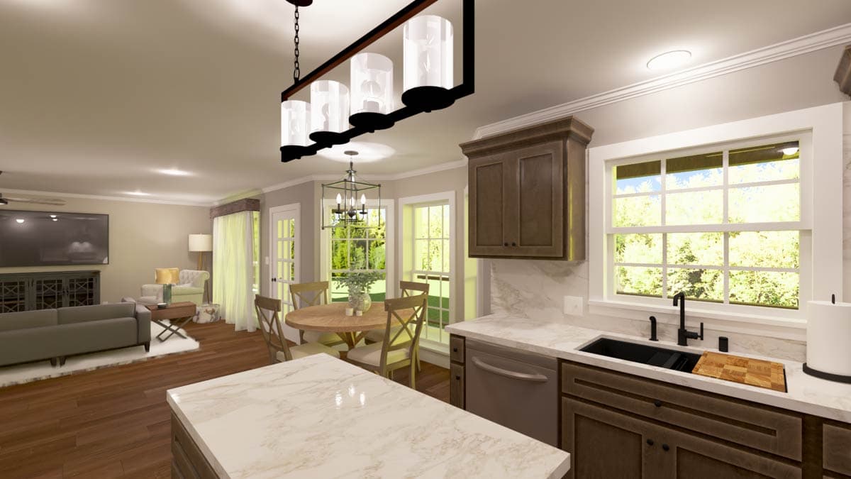 Kitchen with island, dark wood cabinets, stainless steel sink, and dining area with round table by bay windows.