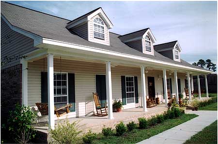 House plan exterior: two-story, vinyl siding, full-length porch with columns, three dormers with arched windows.