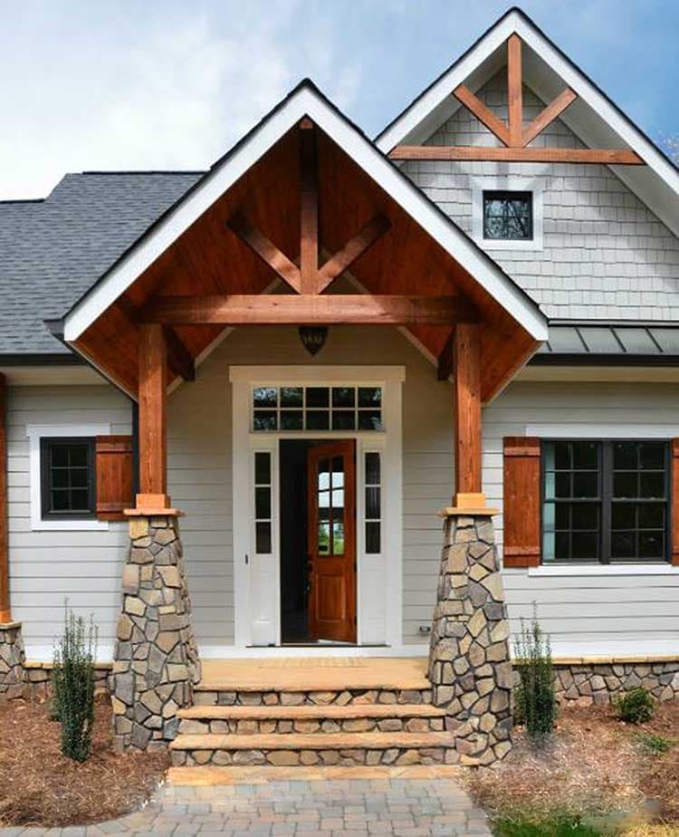 Craftsman style house plan exterior with stone-clad porch columns, wooden beams, and multi-pane windows.