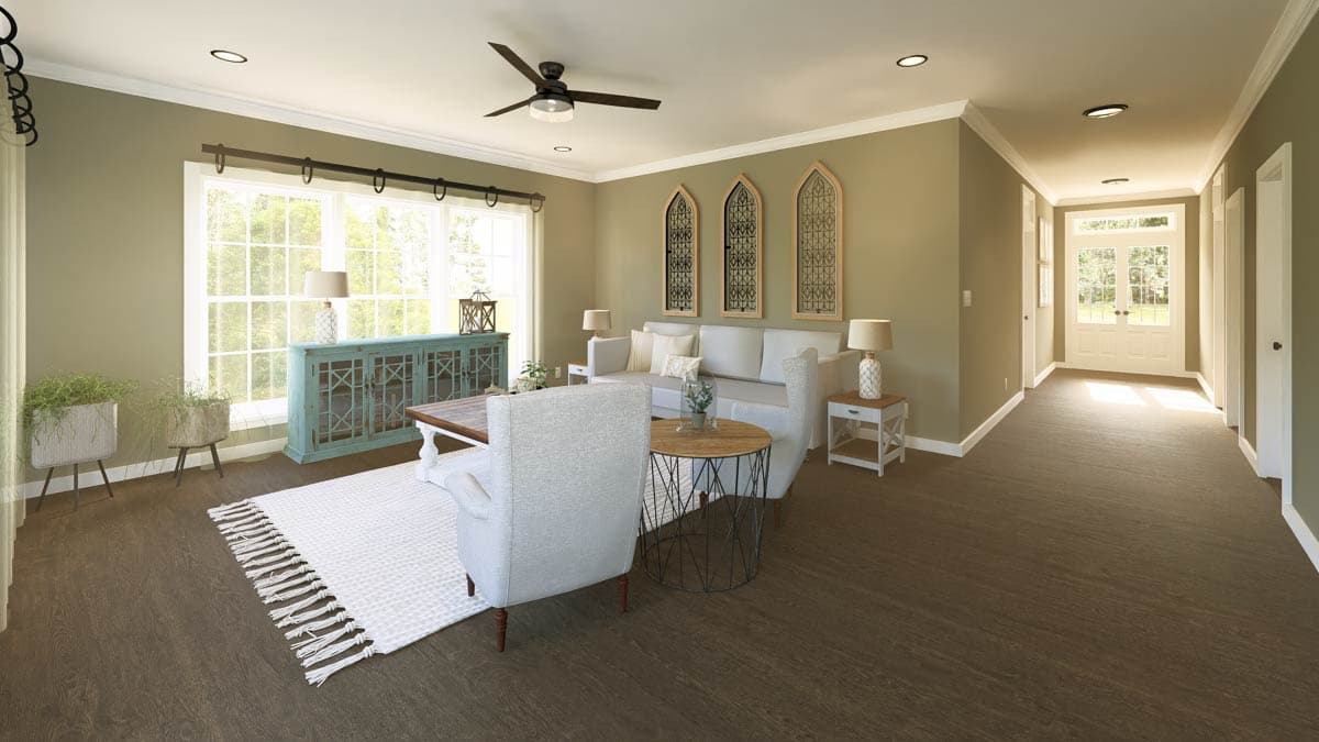 A furnished living room with hardwood floors, a white sofa, and a teal cabinet. Large windows let in plenty of natural light.