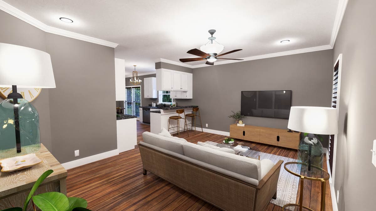 Open concept living area and kitchen with sofa, TV, island with bar stools, and white cabinetry.