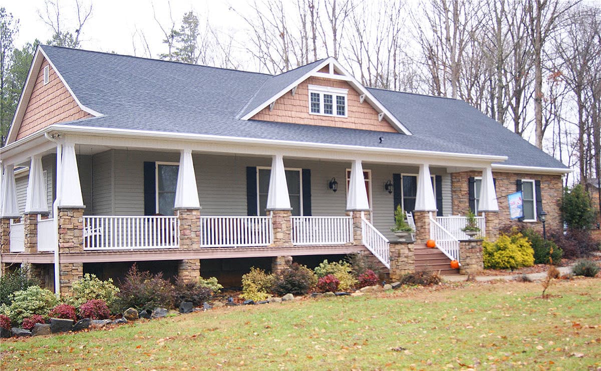 House plan exterior featuring a two-story Craftsman style home with a large porch, gables, and stone accents on the porch columns.