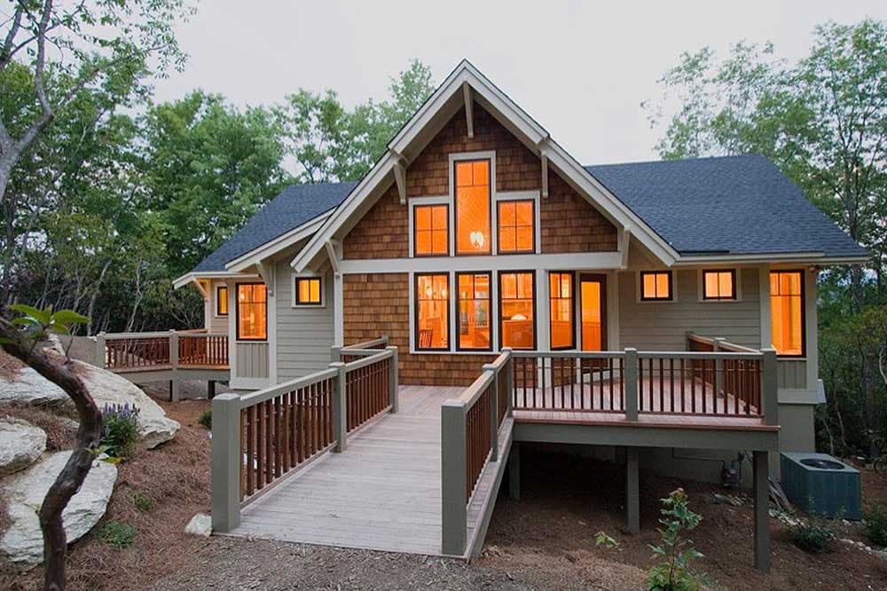 House plan exterior featuring a wooden deck, shingle siding, and a prominent gable with multiple windows.