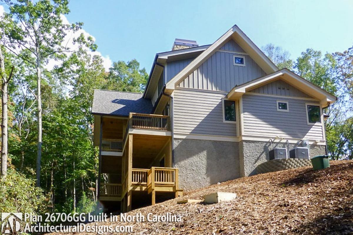 House plan exterior featuring multiple levels of wooden decks, siding, gables, and dormer windows.