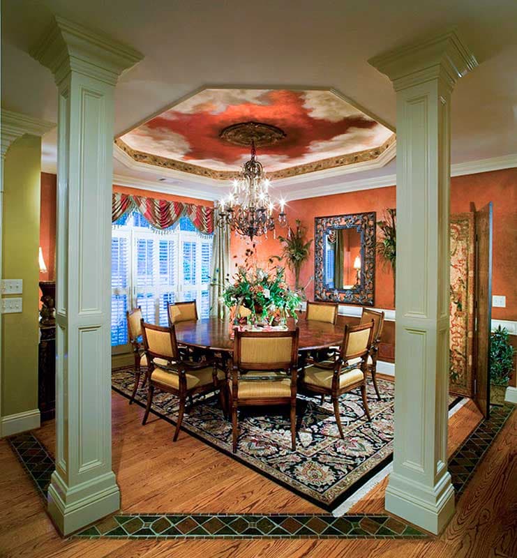 Formal dining room with octagonal tray ceiling, chandelier, dining table with chairs, and decorative floor inlay.