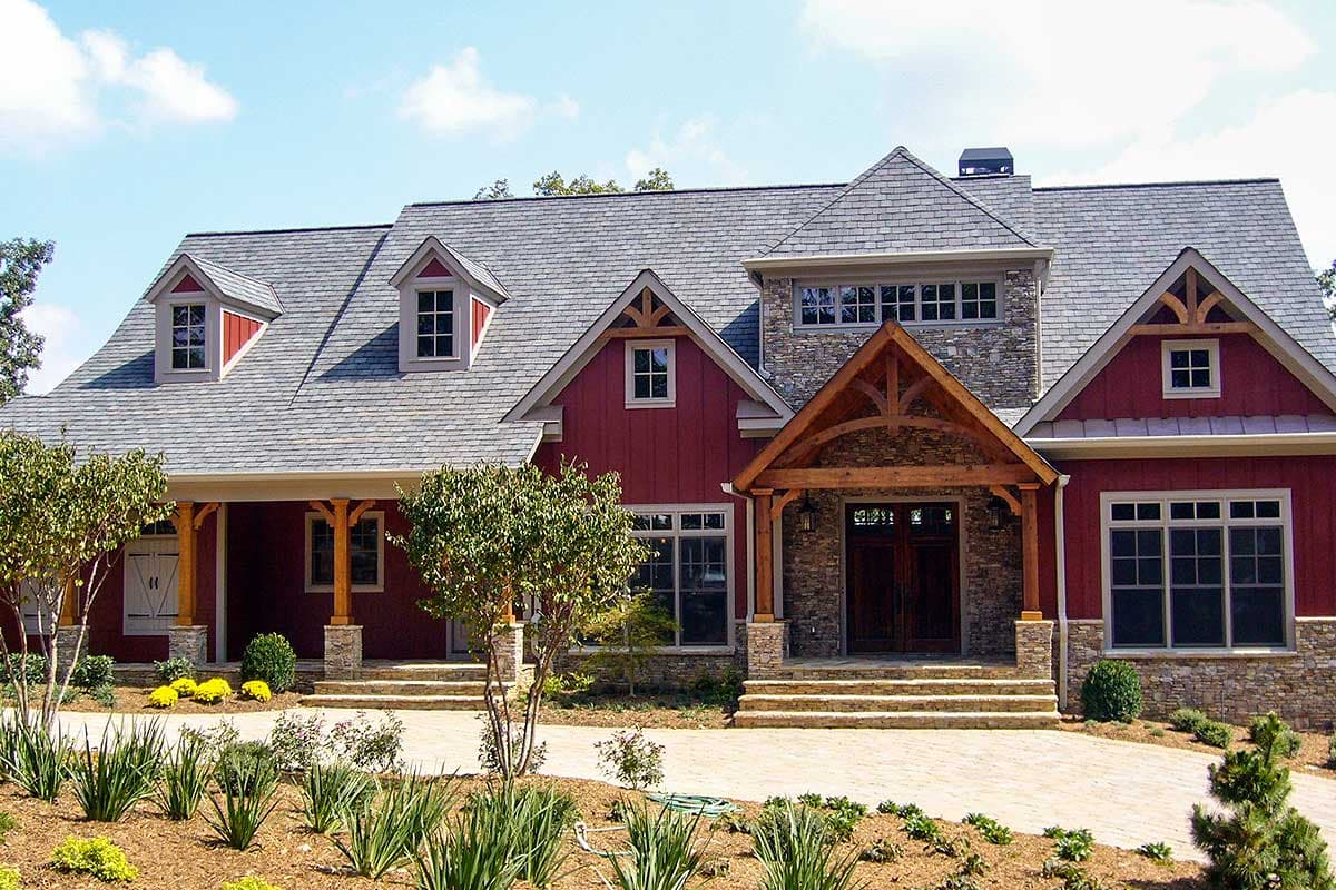 House plan exterior: two-story Modern Farmhouse with stone accents, prominent gables, dormers, and a covered entry with timber framing.