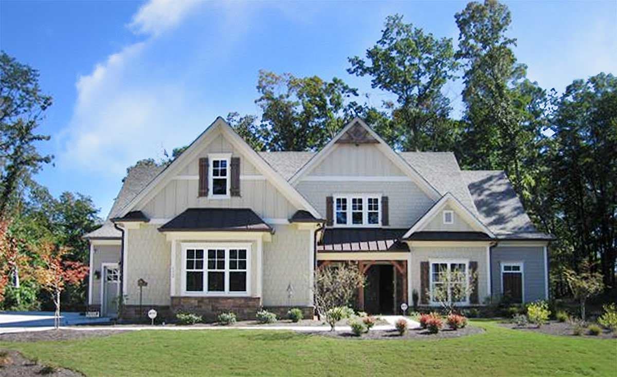 House plan exterior: Traditional style, two stories, prominent gables, covered entryway with wood accents, and multiple dormers.