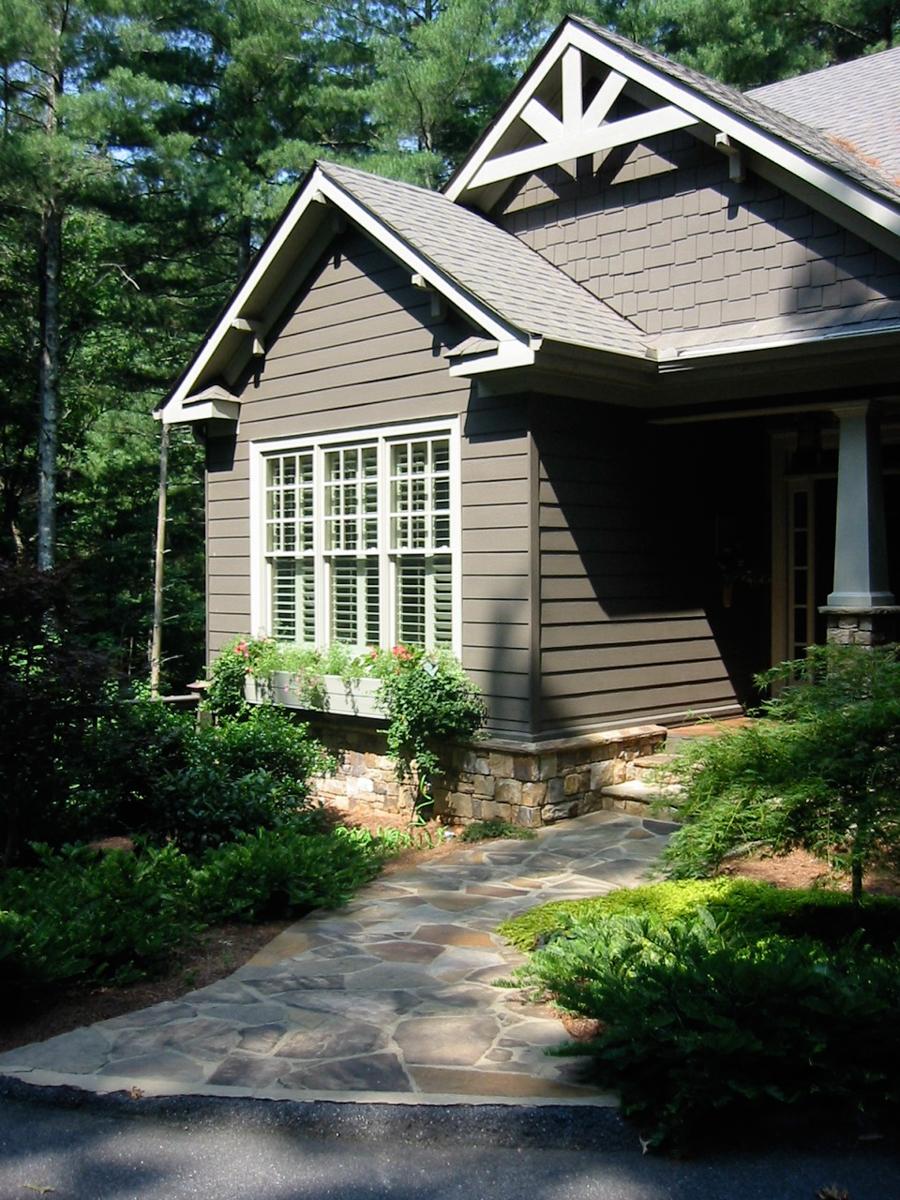 Craftsman style house plan exterior with stone foundation, gabled dormer, and decorative rafter tails.