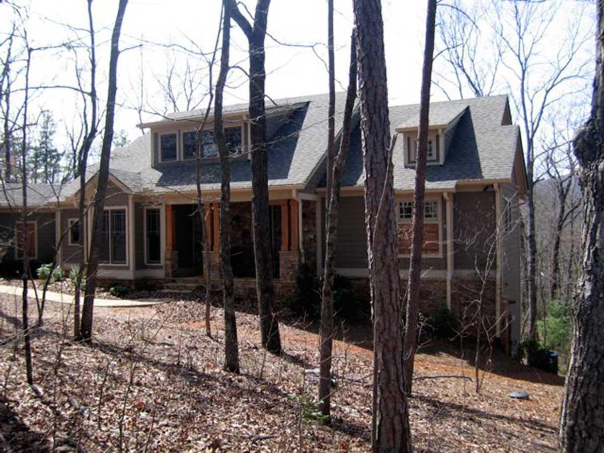 House plan exterior with two stories. Features include a front porch with columns, multiple gables, and dormers. Craftsman style evident.