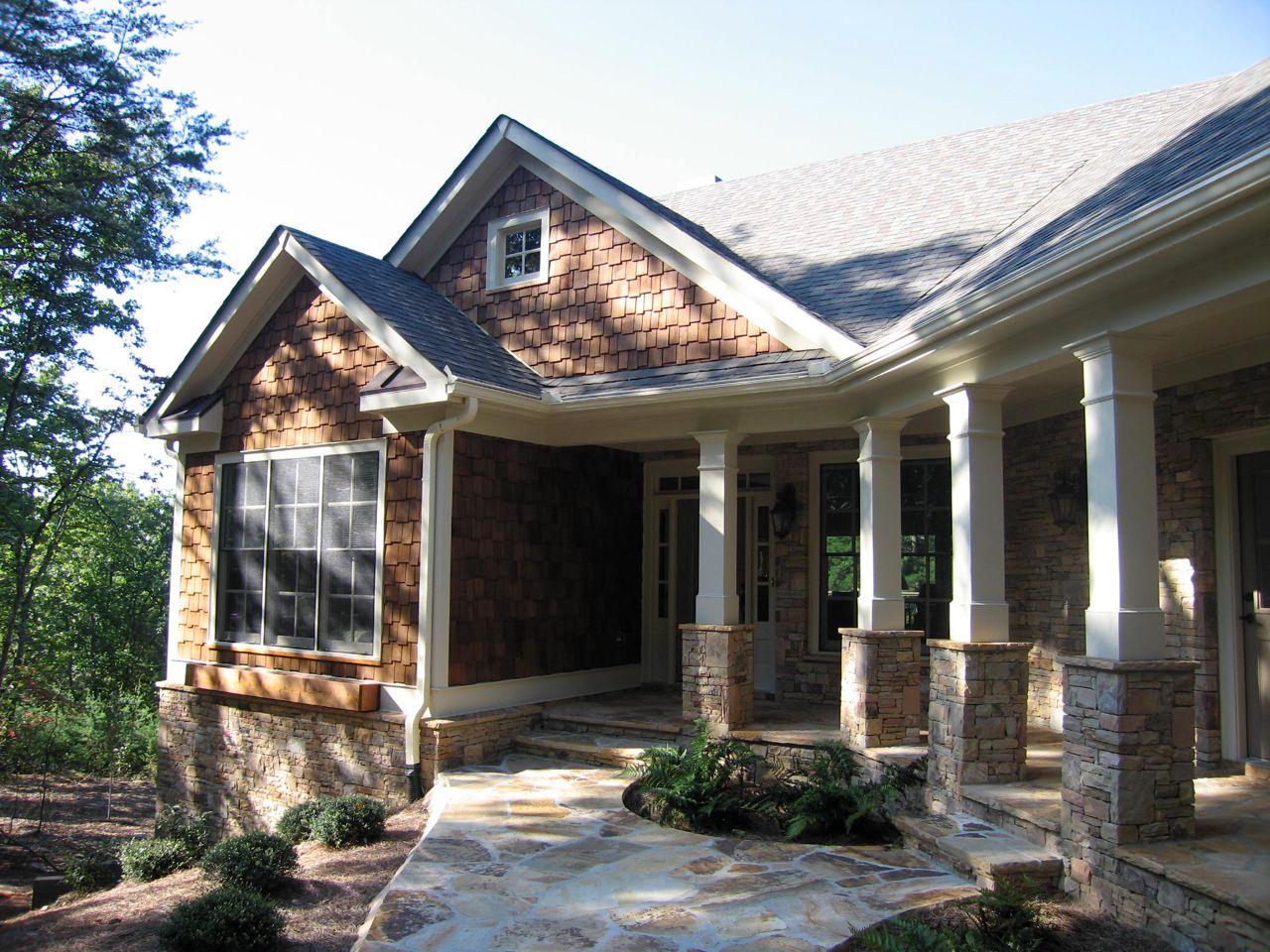 House plan exterior with wood shake siding, stone base, covered porch with square columns, and multiple gables.