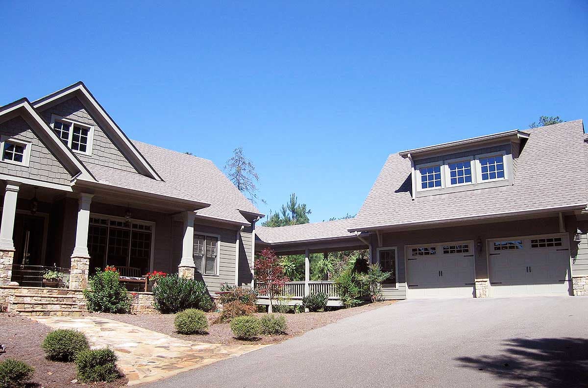 Craftsman house plan exterior with a covered porch, gables, dormers, and a three-car garage.