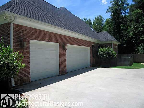 House plan exterior: Brick facade with a three-car garage, asphalt roof, and white fascia and soffits.