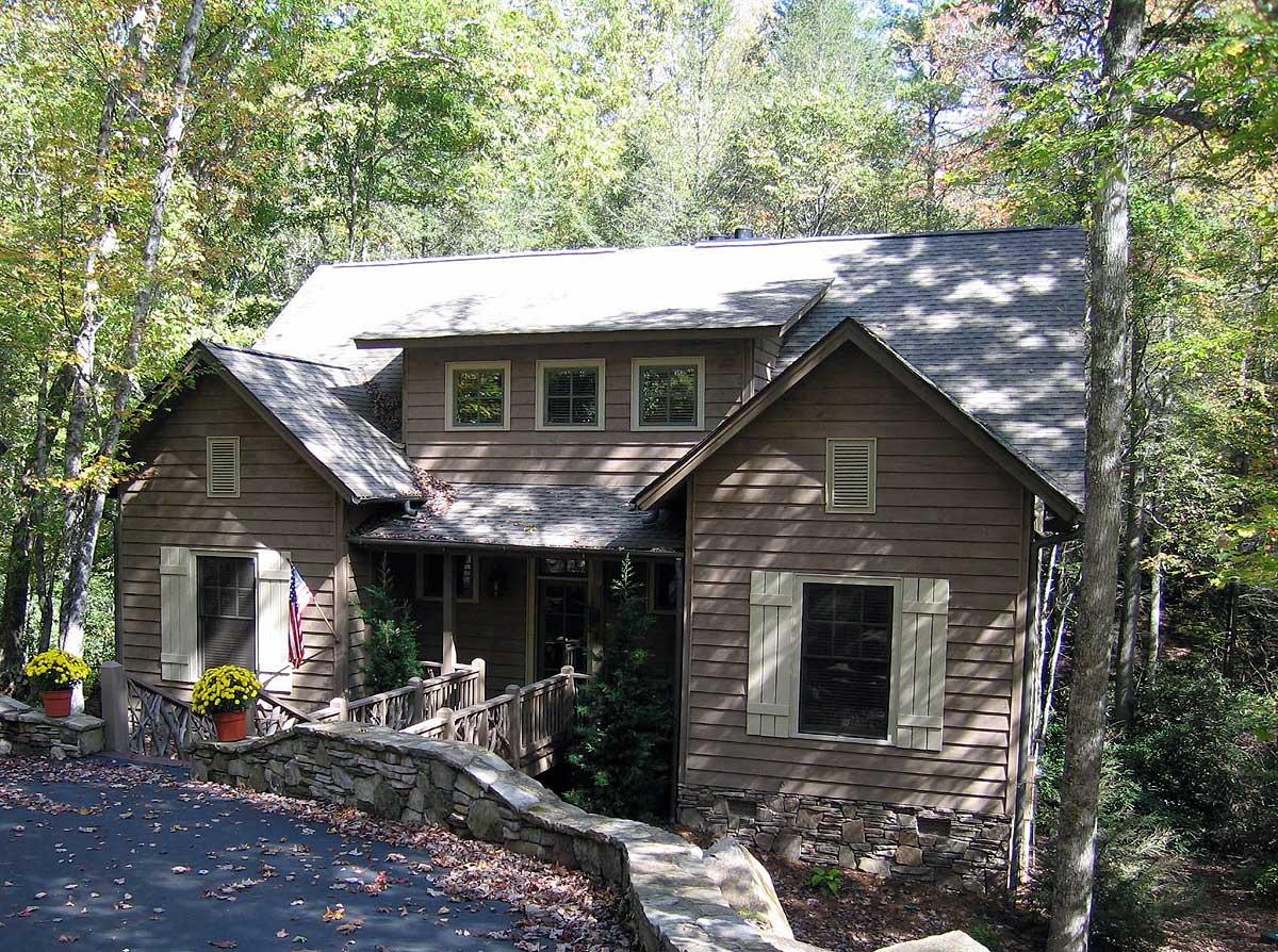 House plan exterior of a two-story home with multiple gables, a covered entry porch, and stone foundation.