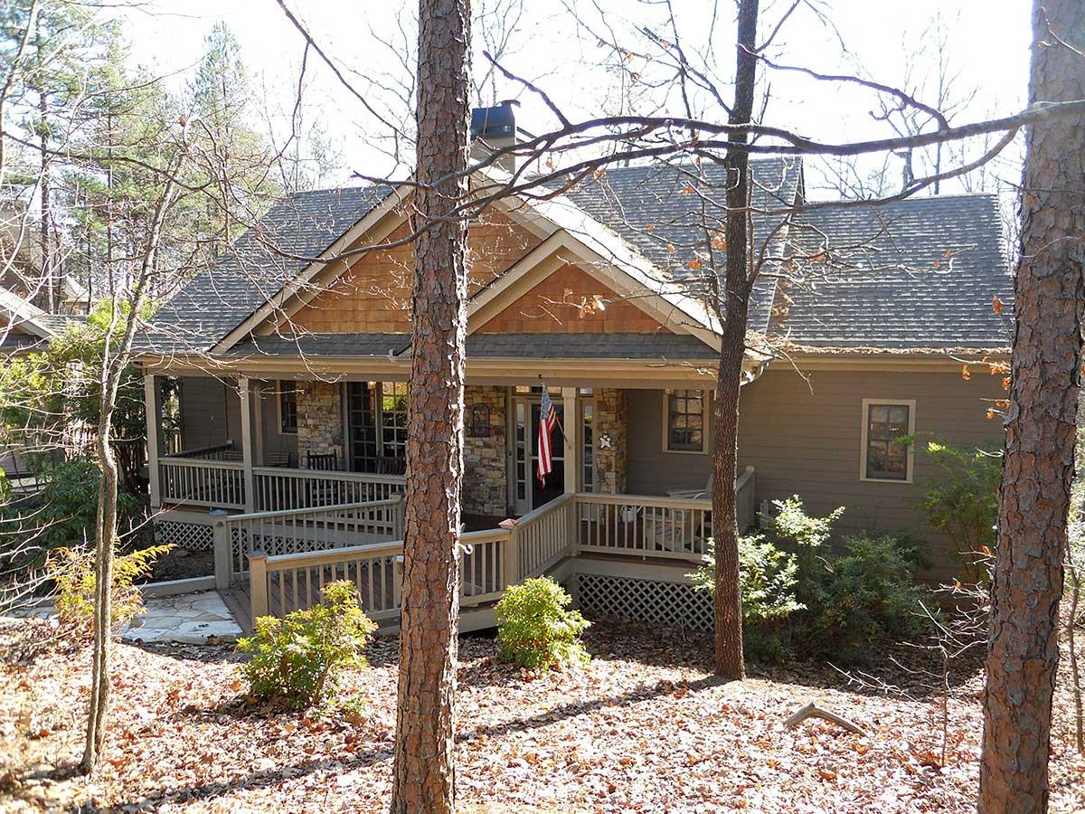 House plan exterior: Craftsman style, 1.5 stories, with covered front porch, stone accents, and gabled rooflines.