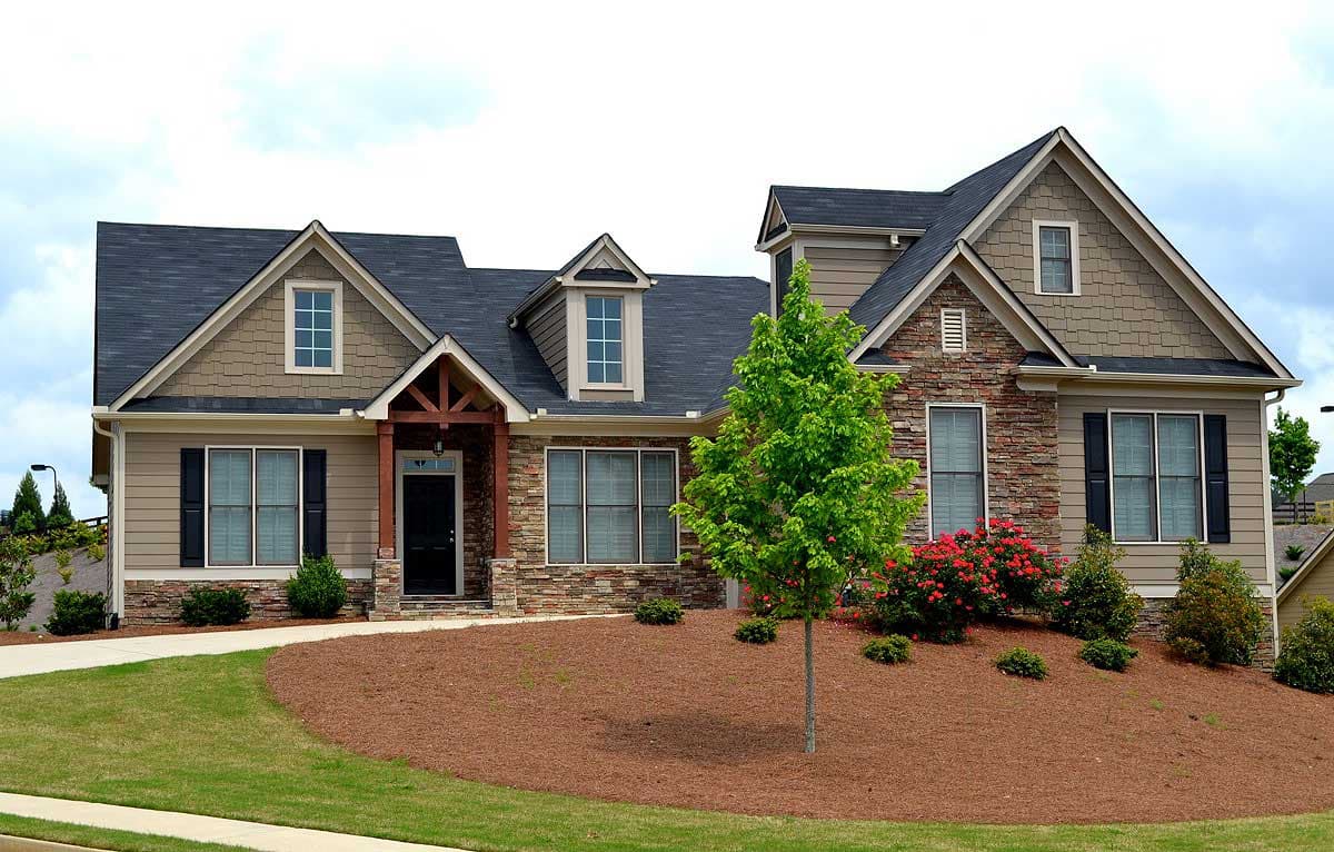 House plan exterior: Two-story Modern Farmhouse with a covered entry, dormers, and stone and siding accents.