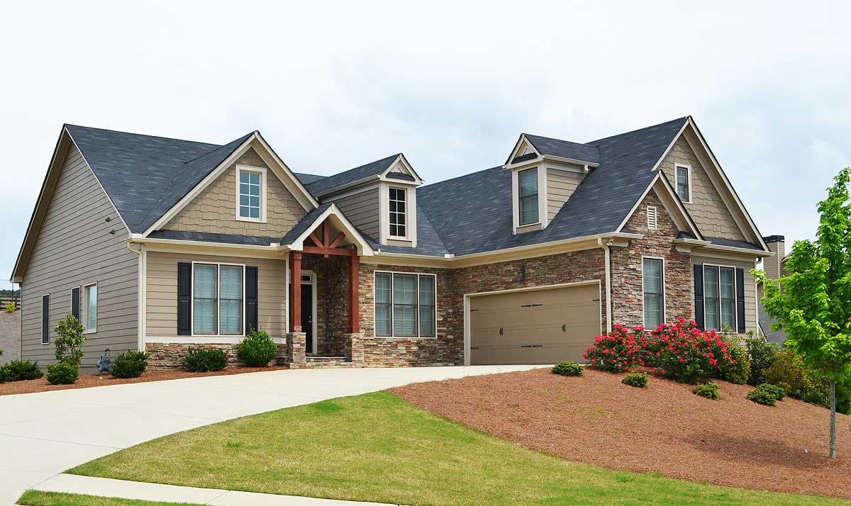 House plan exterior with stone and siding, prominent gables, dormers, and a covered entryway.