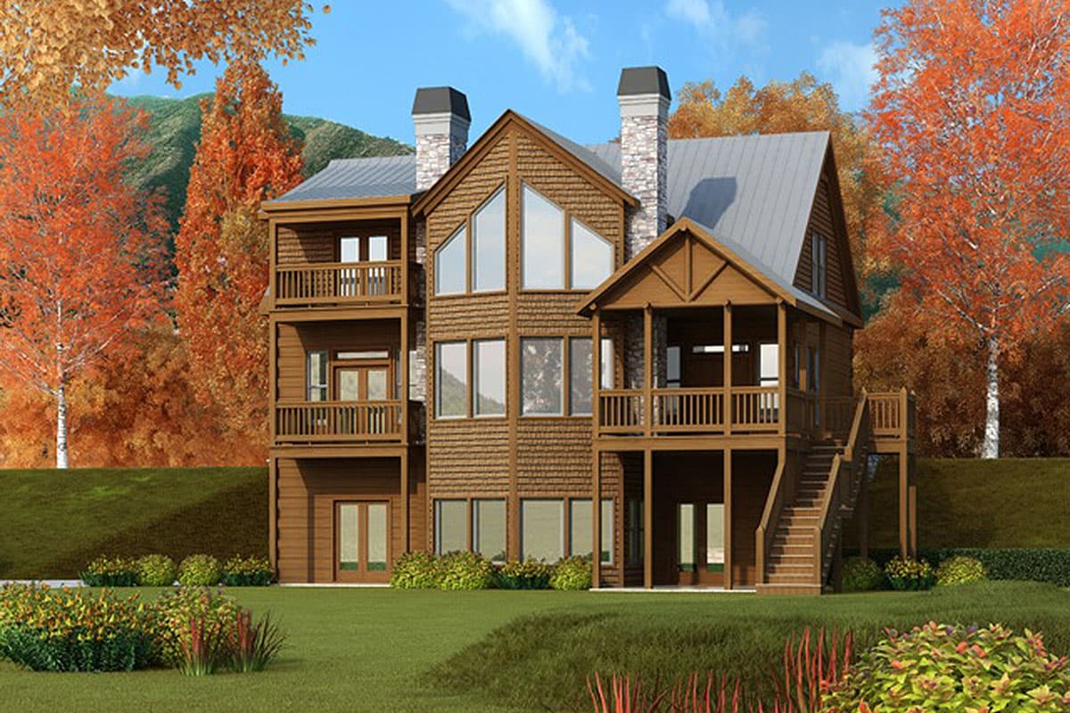 House plan exterior: Three-story mountain lodge style with multiple balconies, stone chimneys, gable roof, and large central windows.