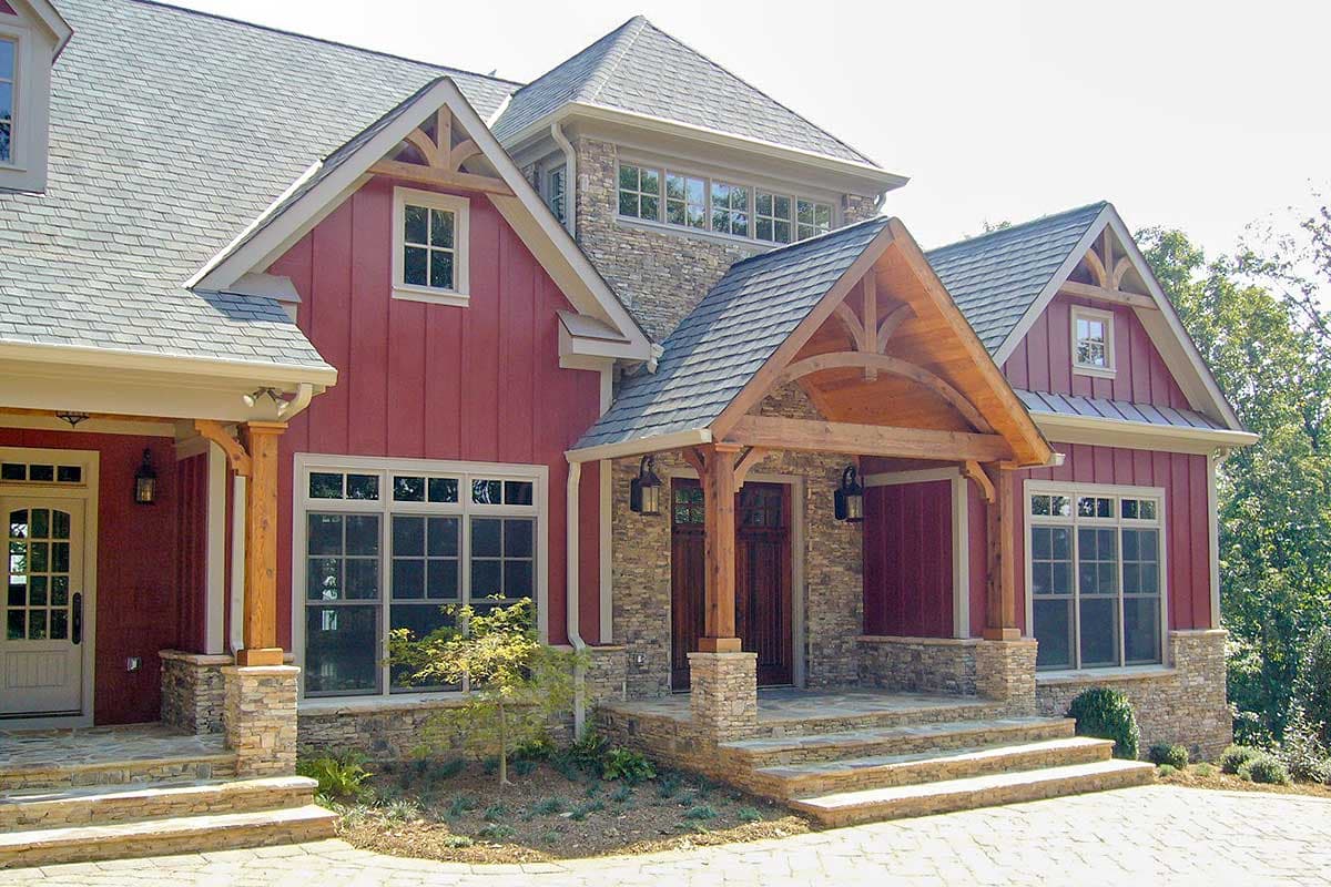 House plan exterior showing a two-story home with stone accents, gables, timbered porch, and board-and-batten siding.