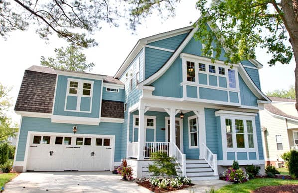 Two-story house plan exterior with a covered porch, dormer windows, distinctive rooflines, and a two-car garage.