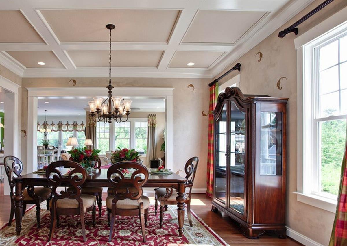 Dining room with coffered ceiling, chandelier, dark wood dining set, and glass-front china cabinet.