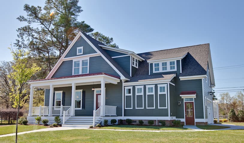 House plan exterior: Two-story home with a wraparound porch, multiple gables, and dormer windows.