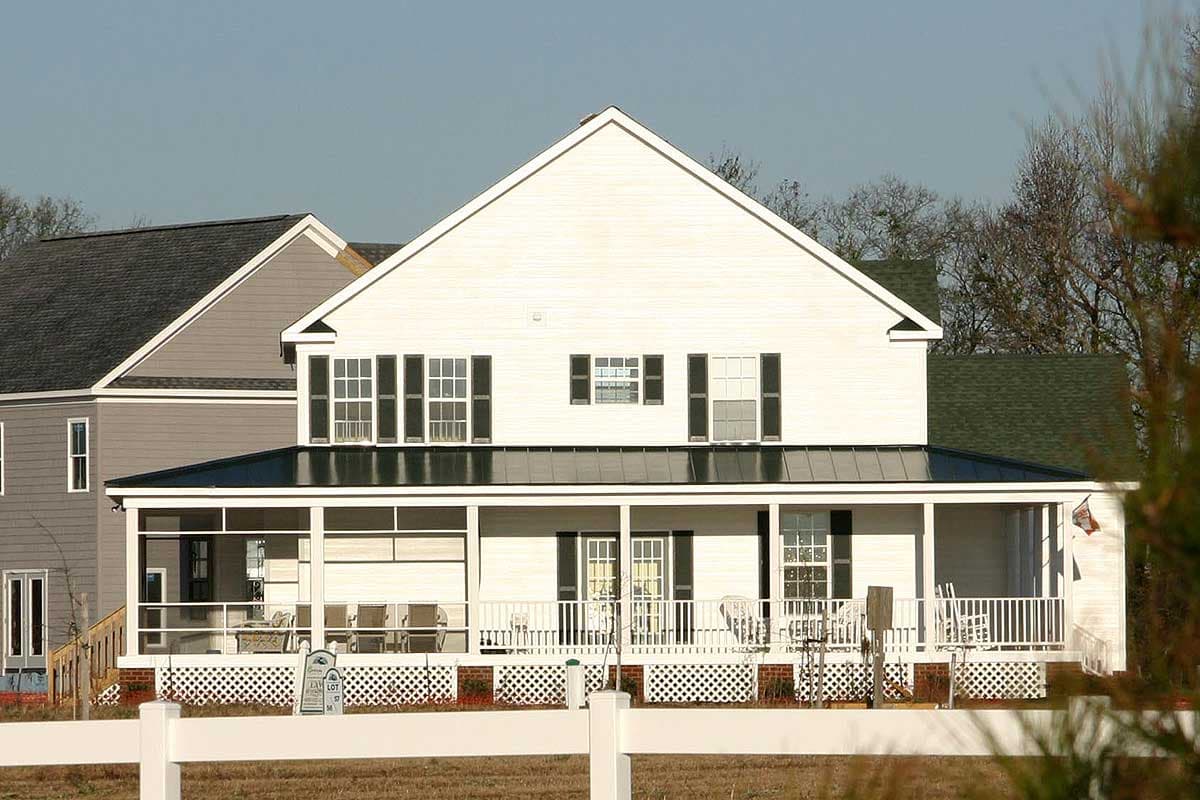 House plan exterior: two-story Modern Farmhouse with wrap-around porch, gables, and numerous windows.