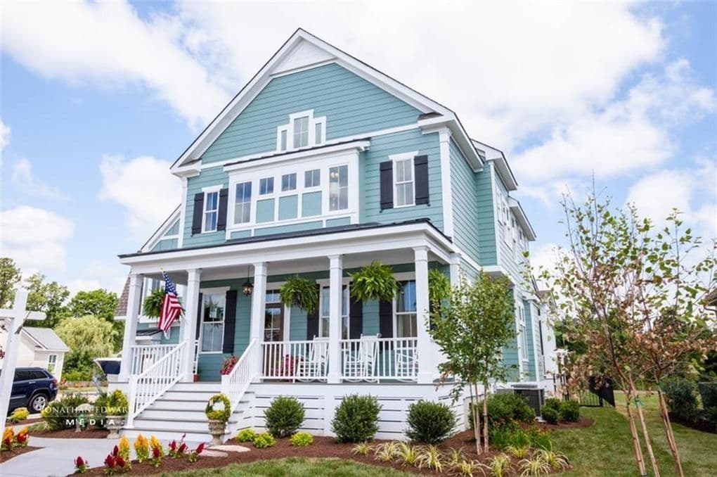 House plan exterior: Two-story coastal style home with a wraparound porch, prominent gables, and dormer windows.