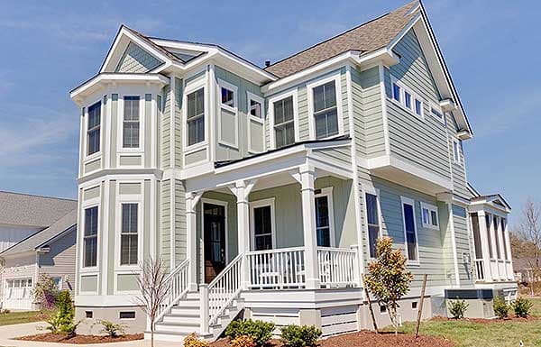 House plan exterior: Two-story home with multiple gables, bay windows, and a covered front porch with decorative columns.