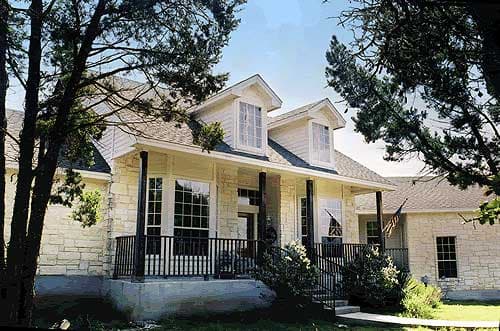 House plan exterior of a two-story home with stone facade, wraparound porch, dormers, and gabled roof.