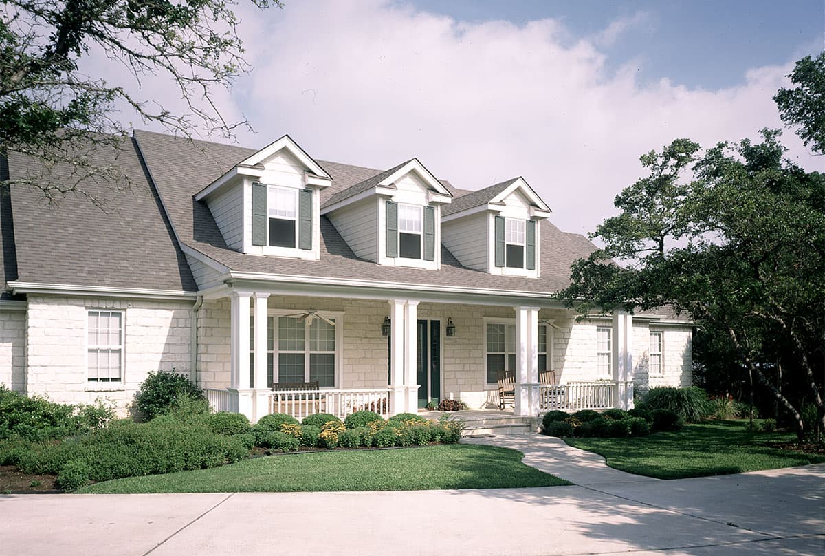 House plan exterior. Two-story home with front porch supported by columns, three dormers, and a gabled roof.