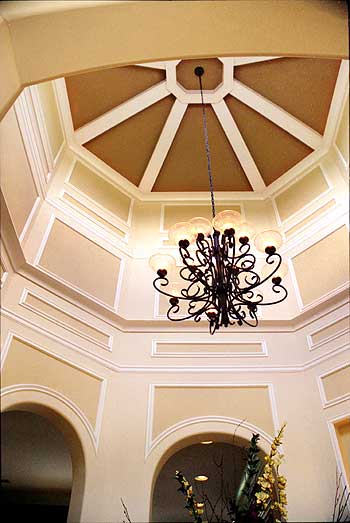 Interior view of an entryway with a coffered octagonal dome ceiling and decorative wrought iron chandelier.