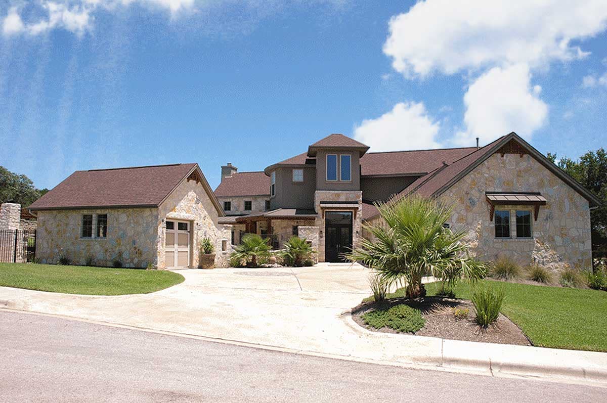 House plan exterior with stone facade, attached garage, and multi-level rooflines.