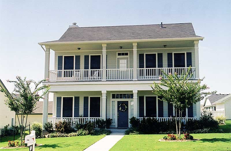 Two-story house plan exterior with a full-width porch, second-story balcony, multiple gables, and a steeply pitched roof.
